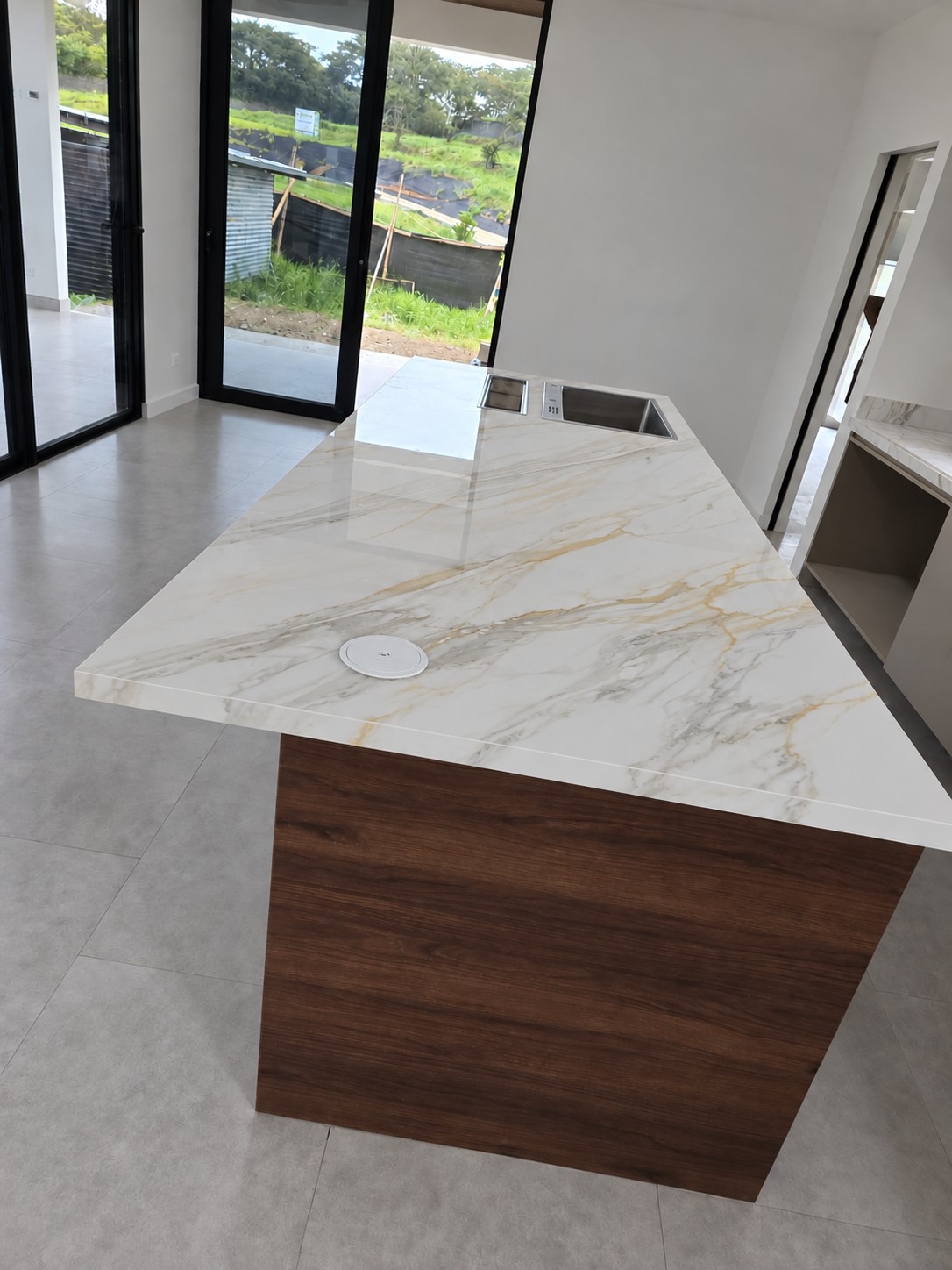 Kitchen island in porcelain surface seen from the living area, view 3