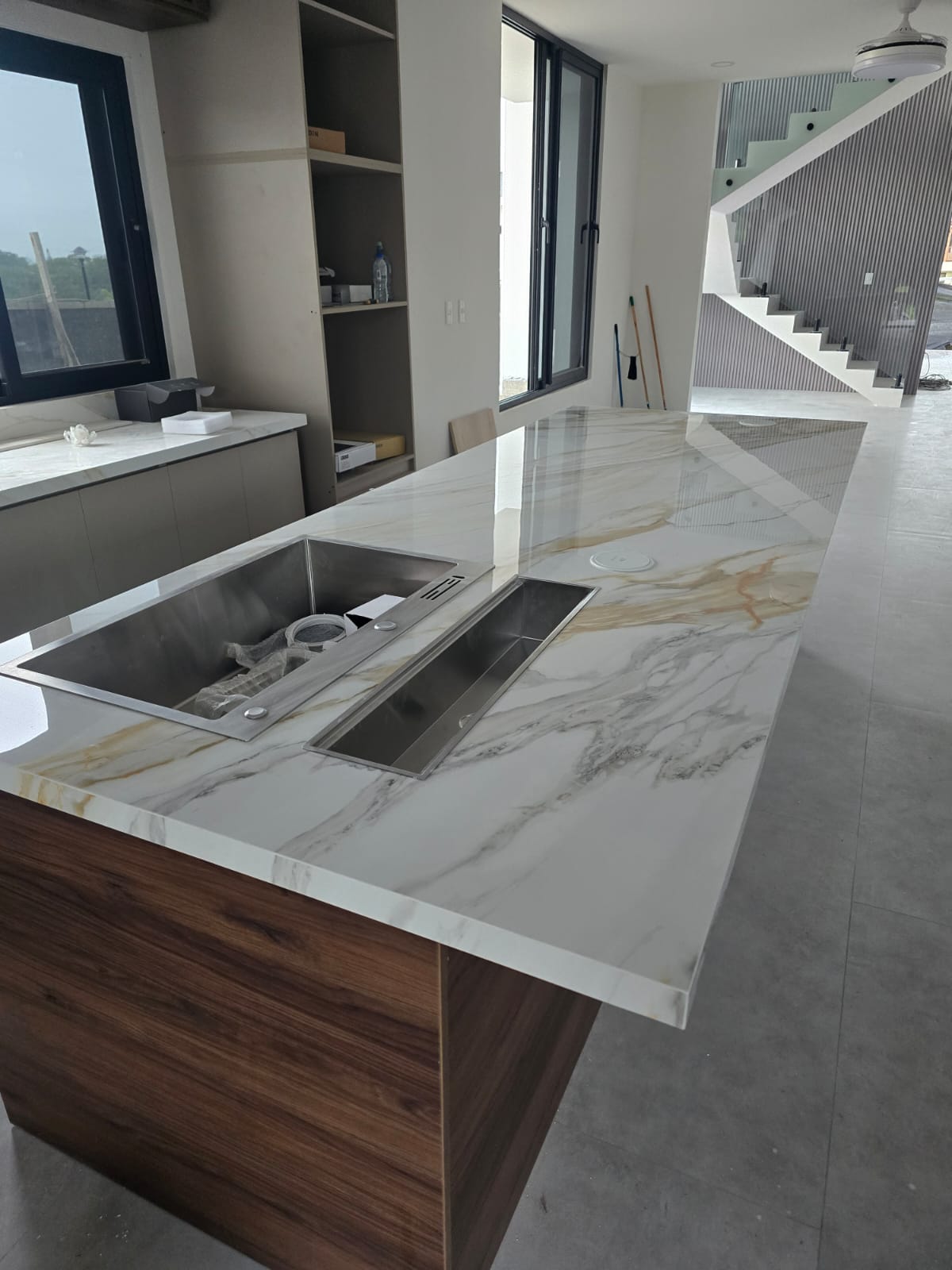 Finished kitchen island with a light porcelain countertop and warm veining, view 1